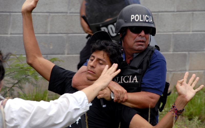 A COPINH protestor with Honduran policeman. Photo: Felipe Canova via Flickr (CC BY-NC).