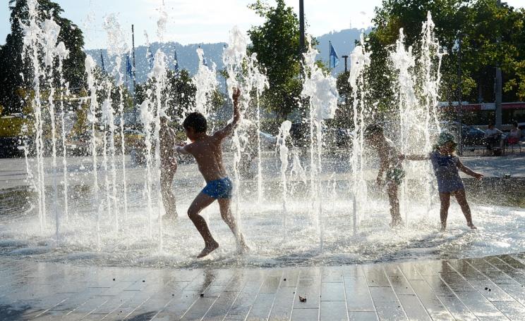 Children playing in water fountain