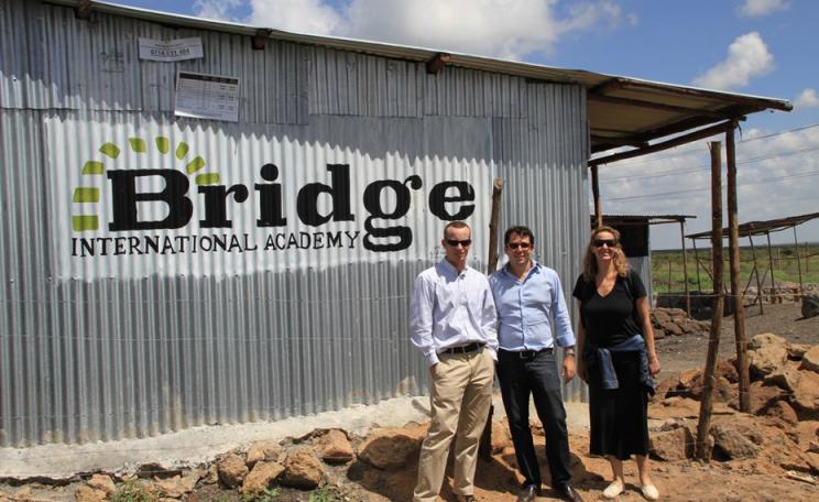 3 people standing outside a Bridge International Schools building