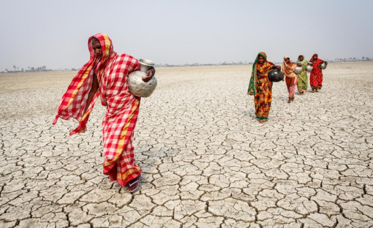 Women walking through desert in search of water