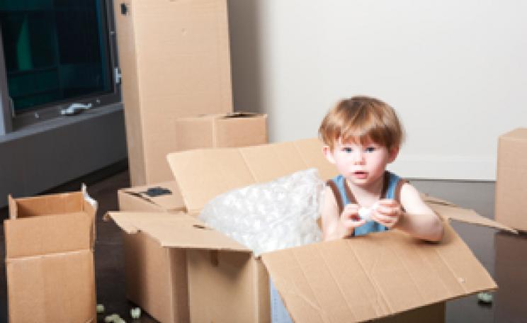 A child plays in an empty box.