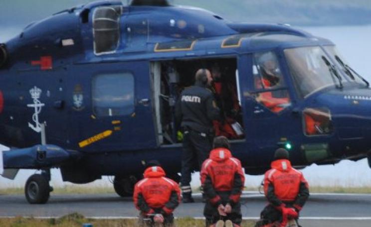 Three arrested protestors are forced to kneel before being loaded into a Danish Royal Navy helicopter. Photo: Sea Shepherd.