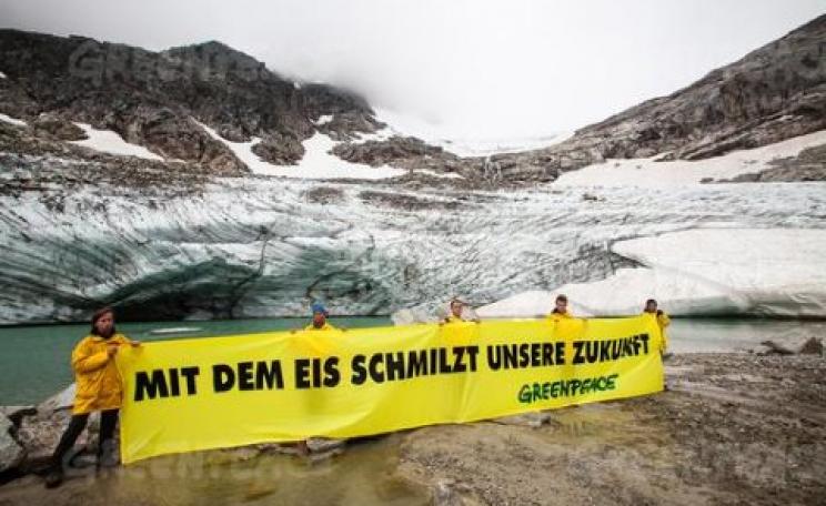 Greenpeace action for an Arctic Sanctuary in front of the melting mouth of Austria's Goldbergkees glacier. The banner reads "our future is melting with the ice".