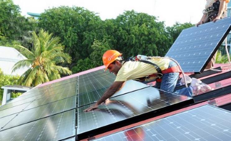 Male, Maldives, October 2010: President Nasheed installs solar panels on the Presidential Residence in 2010 - 18 months before the coup which brought his term of office to an end.