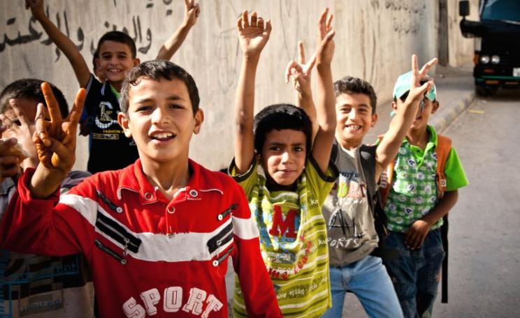 Love and peace! Boys in the Jerash Palestinian refugee camp in Jordan gather to raise their hands in peace signs. Photo: Omar Chatriwala via Flickr (CC BY-NC-ND).