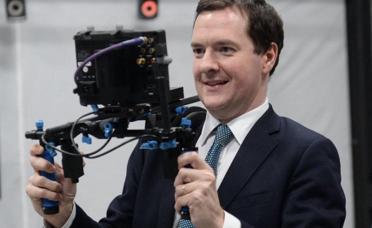 HM Chancellor George Osborne gazing happily at his vision of the future, courtesy of Ealing Studios. Sadly, the device has a fault - and it's actually taking him back to the 1950s. Photo: PA / HM Treasury via Flickr (CC BY-NC-ND).