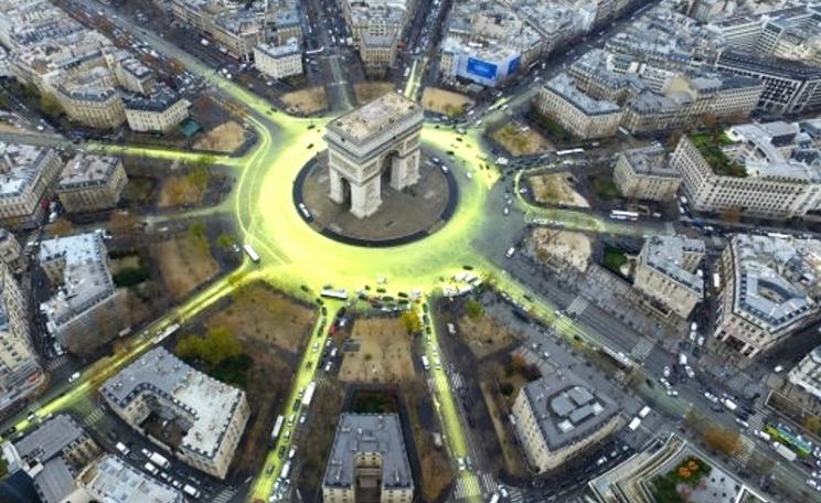 The Arc de Triomphe in Paris, turned into a giant symbol of the Sun after hundreds of bicycles dribbled yellow paint on the Etoile roundabout and surrounding avenues. Photo: Greenpeace.