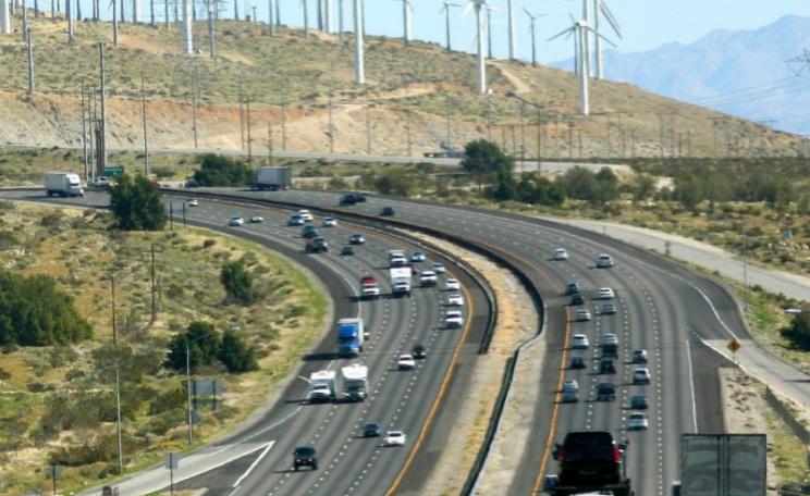 For some decades to come, old and new energy systems will have to maintain an uneasy coexistence - as at Interstate 10 near Palm Springs, California. Photo: Kevin Dooley via Flickr (CC BY).
