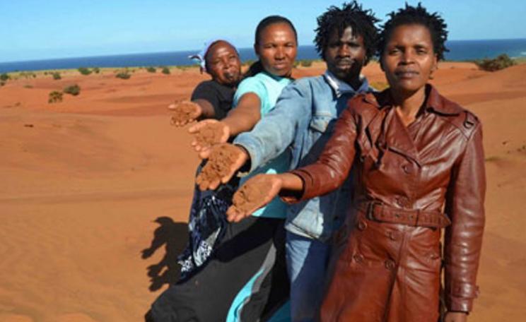 Nonhle Mbuthuma of Amadiba Crisis Committee shows the red sand at Kwanyana Beach near Xolobeni that is at the centre of the dispute. Photo: Loyiso Mpalantshane via Sustaining the Wild Coast.
