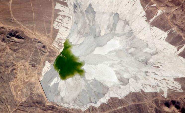 The Escondida copper-gold-silver mine, 170 kilometers (110 miles) southeast of Chile’s port city of Antofagasta. This astronaut photograph features a large impoundment area (image center) containing light tan and gray waste spoil from of the Escondida m