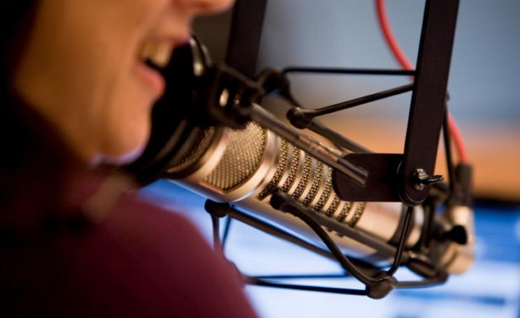 A woman's mouth near a radio stuido microphone