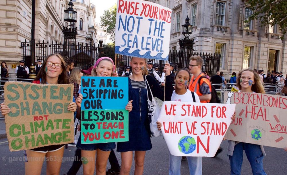 Kids from XR Youth hold up placards at the September climate march