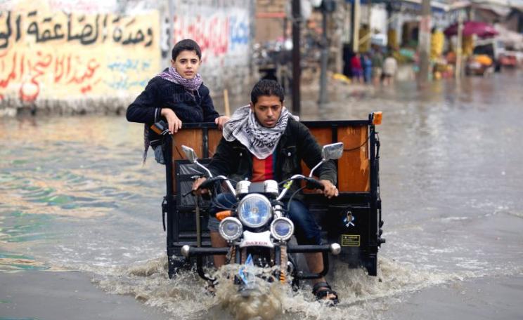 A Palestinian rides his trike through a flooded street following the heavy storms of 2013. Photo: AFP PHOTO  / MOHAMMED ABED via Flickr / Globovisión (CC BY-NC)