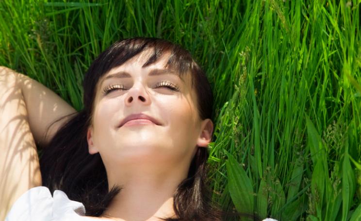 a woman's head rests amongst green grass